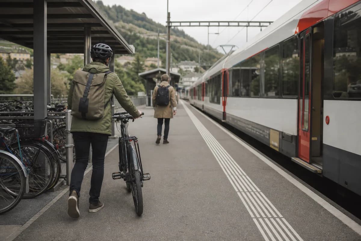 Des voyageurs rejoignent un train à pied et à vélo.