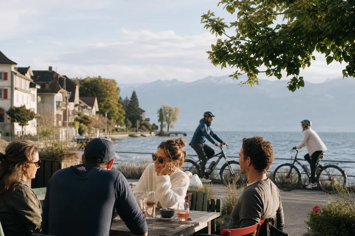 Des habitants se retrouvent sur une terrasse au bord d’un lac.